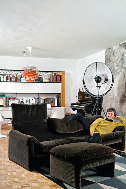 Héctor Elizaga está recostado en un sofá Maralunga con reposapiés, diseñado por Vico Magistretti y producido en los años ochenta por Cassina.