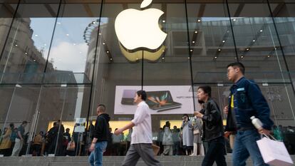 Consumidores chinos pasean frente a una tienda de Apple en Shanghái.