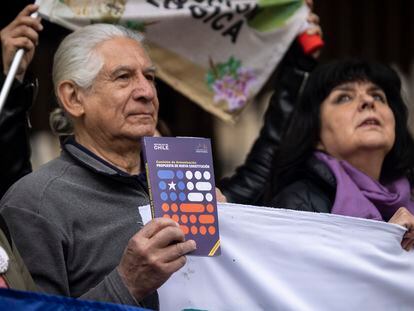 Un hombre sostiene un ejemplar de la propuesta de nueva Constitución durante un acto en Santiago de Chile.
