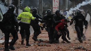 Policías antidisturbios retienen a un manifestante durante una jornada de protestas, en Madrid, un municipio cercano de Bogotá.