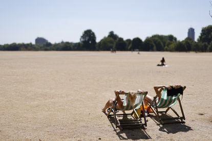 En primer término, dos mujeres toman el sol en Hyde Park, en el centro de Londres (el Reino Unido), este viernes. 
