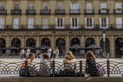 Several young women rest on the benches in Bilbao's Plaza Nueva.