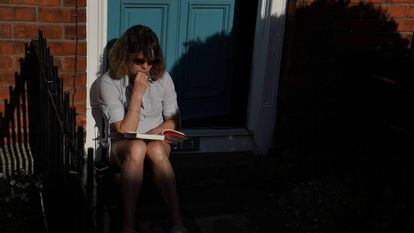 Una mujer lee un libro, el pasado día 11 durante su confinamiento en Dublín, Irlanda. 