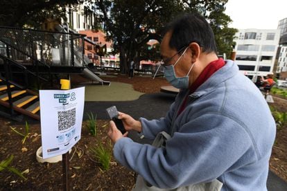 A man scans a QR code to enter a park in Melbourne, Australia.