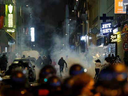 Varios manifestantes huyen de los policías franceses que usan gases lacrimógenos en París el pasado domingo.