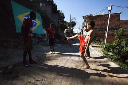 Ni&ntilde;os juegan al f&uacute;tbol en la periferia de Sao Paulo