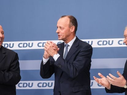 El futuro presidente de la CDU, Friedrich Merz, entre los otros dos candidatos, Helge Braun (izquierda) y Norbert Röttgen, durante el acto de presentación de los resultados, este viernes en Berlín.