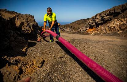 Rubén Barreto, jefe de fontaneros de Los Llanos de Aridane colocaba el viernes una tubería para llevar el agua a una vivienda. Las tuberías no se pueden enterrar por el calor que aún desprende la lava.