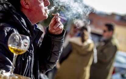 Un hombre fuma un cigarrillo en una terraza de Madrid.