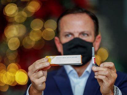 El Gobernador de São Paulo, Joao Doria, muestra una caja y una ampolleta de Coronavac durante una rueda de prensa celebrada el 7 de diciembre.