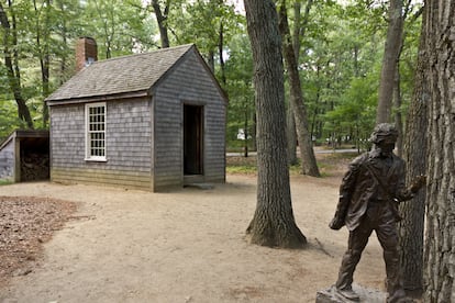 Réplica de la cabaña de Thoreau y estatua del escritor cerca de Walden.