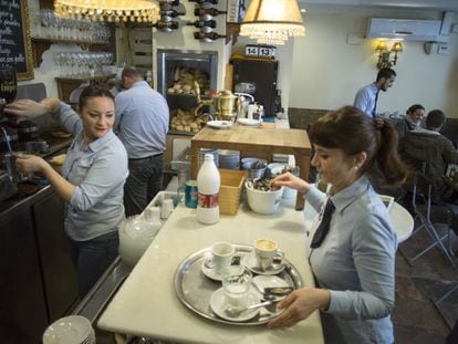 Dos mujeres y otros camareros en una cafetería de Sevilla. 