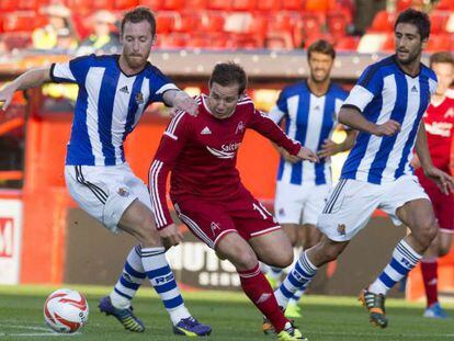 Pawlett se lleva el balón frente a dos jugadores de la Real 