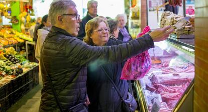 Una pareja hace la compra en un mercado de Sevilla.