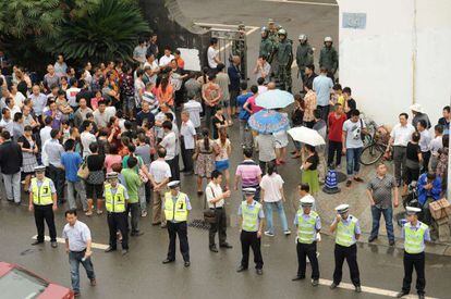Policías y agentes paramilitares vigilan las oficinas gubernamentales en Shifang el día después de la cancelación del proyecto.