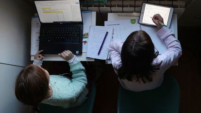 Dos niñas hacen los deberes del colegio en su casa, durante la pandemia de covid-19.