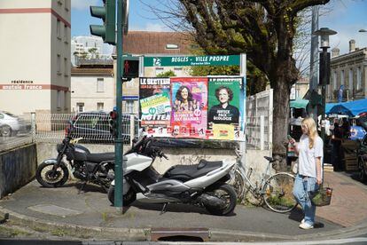 A young woman walks past some political posters on a street in Bègles, on April 11.