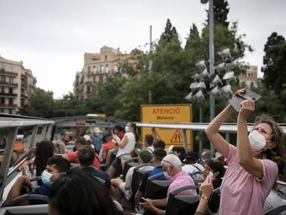 Una turista fotografía desde el autobús descapotable