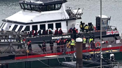 Inmigrantes escoltados por la Policía a su llegada a la costa de Dover.