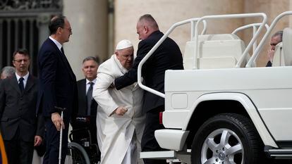 El papa Francisco es ayudado a sentarse en una silla de ruedas durante la audiencia de este miércoles en el Vaticano.