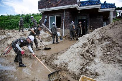 Soldados surcoreanos limpian los escombros frente a una de las viviendas afectadas por las fuertes lluvias en Yecheon-gun, el lunes 17 de julio. 