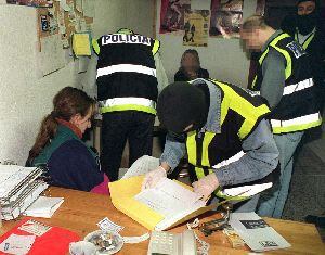 Agentes del Cuerpo Nacional de Policía registran una sede de Haika en presencia de una de las detenidas.
