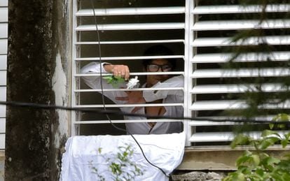Cuban dissident Yunior García pokes his fist out of the window of his apartment in Havana, on November 14, 2021.