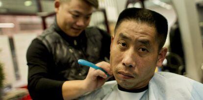 Un hombre se corta el pelo en una de las muchas peluquerías chinas de Usera.