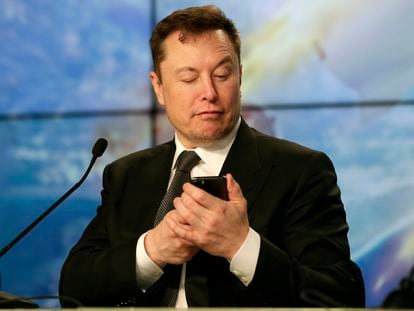 El multimillonario Elon Musk bromea usando su celular durante una conferencia de prensa, en 2020.
