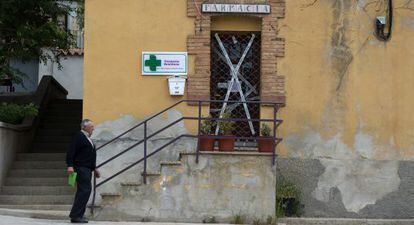 Un vecino pasea en Palomar de Arroyos (Teruel) frente a la farmacia cerrada por la Guardia Civil.