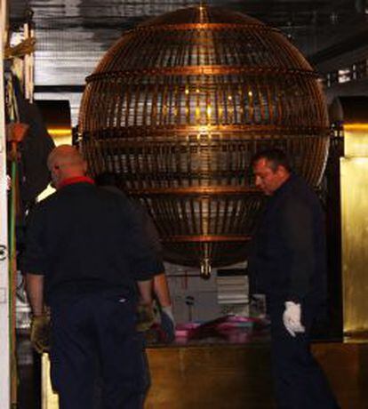 Dos trabajadores durante el traslado de los bombos de la loter&iacute;a de Navidad al Teatro Real de Madrid.