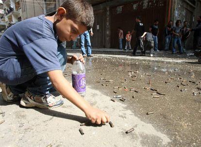 Varios niños recogen casquillos de bala procedentes de un combate nocturno entre clanes rivales ayer en la ciudad de Trípoli (norte).