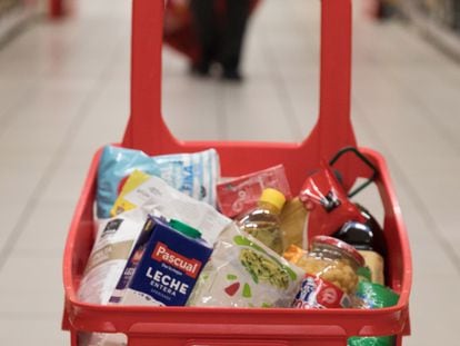 Cesta de la compra con productos básicos en un supermercado de Madrid.
