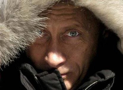 Putin se cubre la cabeza con una capucha durante una gira electoral por Siberia.