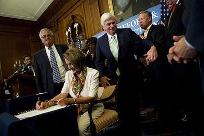 La presidenta de la Cámara de Representantes estadounidense firma la reforma financiera ante varios senadores.