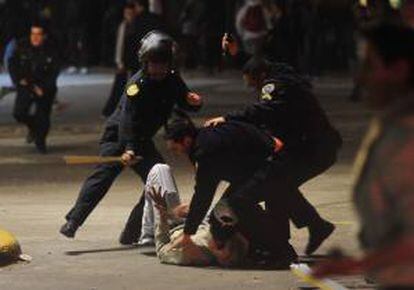 Fotografía cedida por la Agencia Telam que muestra
a dos policías enfrentados con manifestantes durante los incidentes que se registraron a las puertas de unas de las principales terminales ferroviarias de Buenos Aires (Argentina). EFE/Archivo