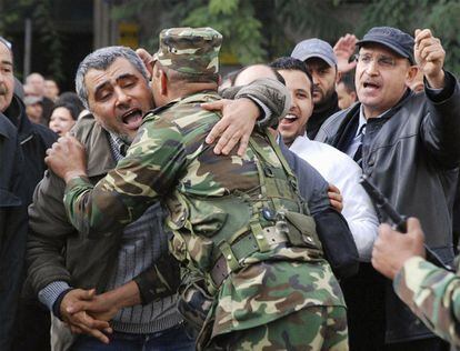 Un hombre abraza a un soldado durante la manifestación a la que acudieron más de 5.000 personas  para pedir la dimisión inmediata del presidente tunecino Zine el Abidine Ben Ali.