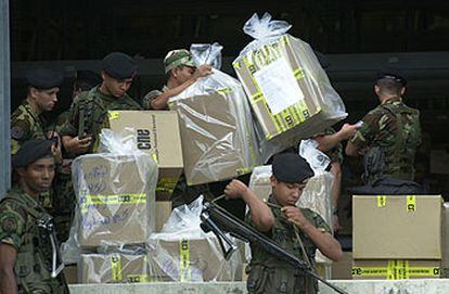 Soldados venezolanos descargan cajas con papeletas para la auditoría del referéndum del domingo.