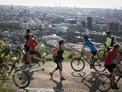 Ciclista y corredores salen a hacer deporte por la Carretera de les Aigües, en Barcelona.
