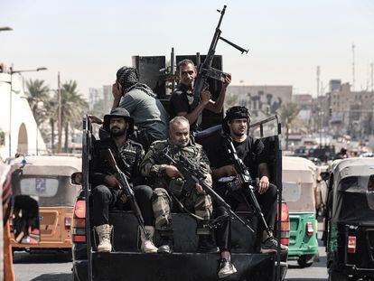 Miembros armados de Saraya al-Salam, el ala militar vinculada al clérigo chiíta iraquí Muqtada Al-Sadr, conducen un vehículo durante los enfrentamientos con las fuerzas de seguridad iraquíes, en la Zona Verde de Bagdad, este martes.
