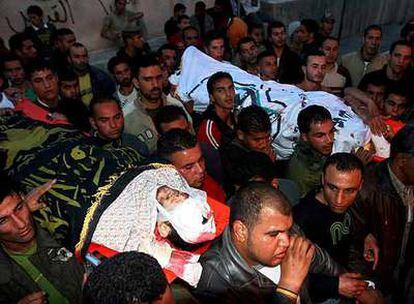 Varios palestinos trasladan los cuerpos de dos militantes muertos hoy en ataque israelí en la ciudad palestina de Yenín
