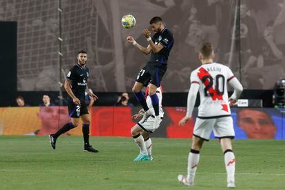 Carrasco pone un centro de cabeza durante el partido de la Liga entre el Atlético de Madrid y el Rayo Vallecano, este domingo.