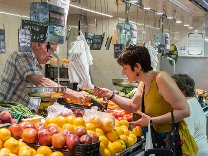 Una mujer paga su compra en una frutería de Barcelona.