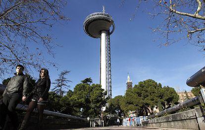 Una pareja pasea junto al faro de Moncloa.