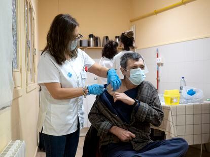 Una sanitaria vacuna la dosis de refuerzo contra la covid a un usuario de la Fundació Arrels en Barcelona.