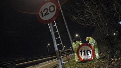 Dos operarios cambian los límites de velocidad en una autopista, en marzo pasado.