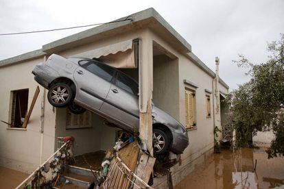 Vehículo atrapado en la entrada de una vivienda de la ciudad griega de Mandra por las fuertes lluvias que han afectado a la región de Ática.