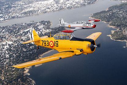 Un T-6 Texan estadounidense (amarillo) volando en formación con un Saeta, el primer reactor español, ayer sobre el embalse de Valmayor.