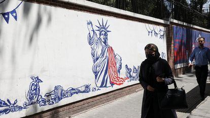 Una mujer pasa junto a una pintada antiamericana en lo que fue un muro de la Embajada de EE UU en Teherán, el pasado 16 de agosto.