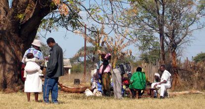 Embarazadas y madres con sus maridos y bebés reciben VCT (consejo voluntario y tratamiento) bajo la fresca sombra de un árbol en el hospital rural de Tsholotsho.